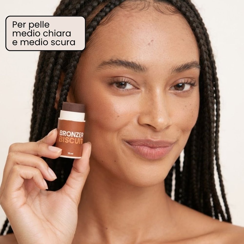 Modella con pelle medio-scura che tiene in mano il bronzer in stick Biscuit di Enooso